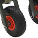 Close-up of heavy-duty steel folding fishing trolley wheels with red rims and black tires