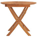Round folding garden table in solid teak wood with crossed legs on white background