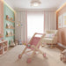 Pink wooden doll stroller in a pastel nursery with plush toys and picture books