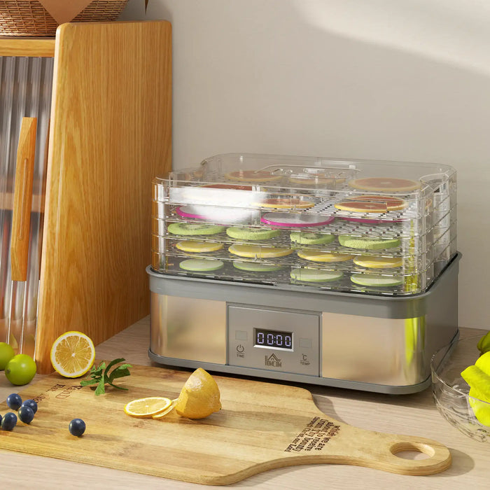 Food dehydrator with slices of fruit on a wooden cutting board