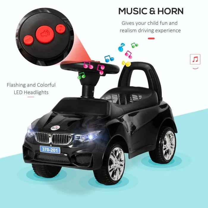 Black foot-to-floor ride-on car for toddlers with music, horn, and LED headlights