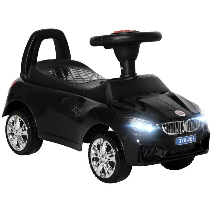 Black foot-to-floor ride-on car toy with flashing headlights and chrome wheels for toddlers