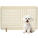 Small white dog sitting next to a beige pet gate on a white background