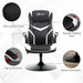 Black and white faux leather gaming chair with flip-up armrests and round steel base.
