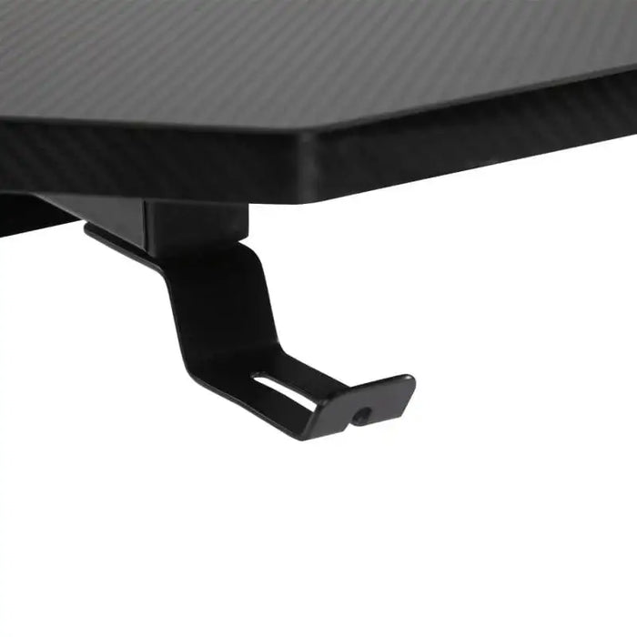 Black gaming desk headphone hook detail on carbon fiber textured surface