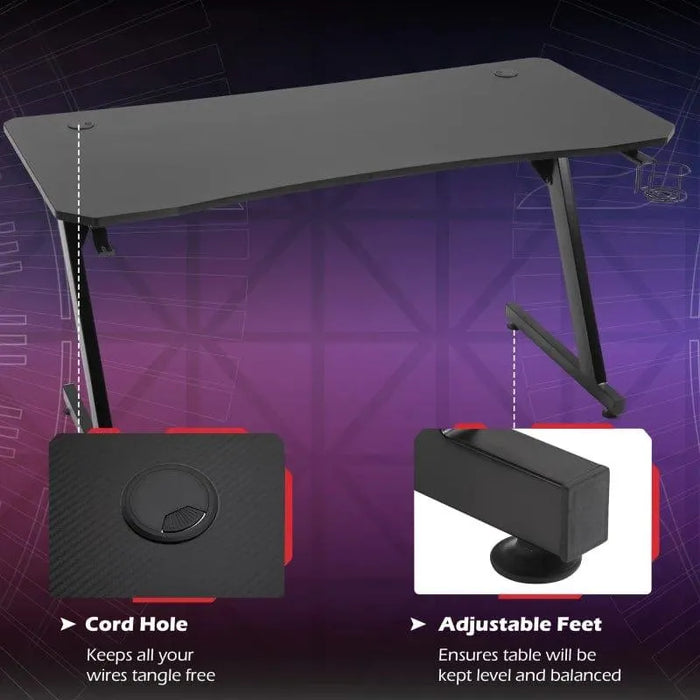 Black Z-shaped gaming desk with cable holes, adjustable feet, headphone hook, and sturdy frame