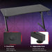 Black Z-shaped gaming desk with cable holes, adjustable feet, headphone hook, and sturdy frame