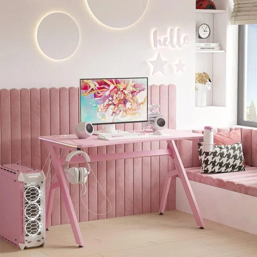 Pink gaming desk with RGB LED lights, monitor, speakers, pink PC case, and stylish decor
