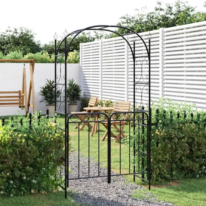Black powder-coated steel garden arch with gate in a landscaped backyard setting