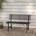 Black powder-coated steel garden bench with slatted backrest on wooden deck