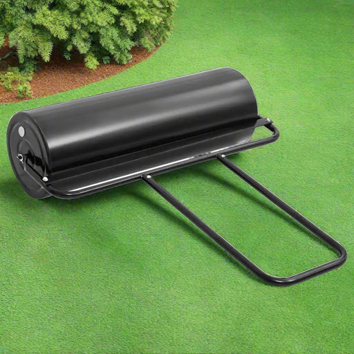 Heavy duty black iron garden lawn roller with handle on green grass