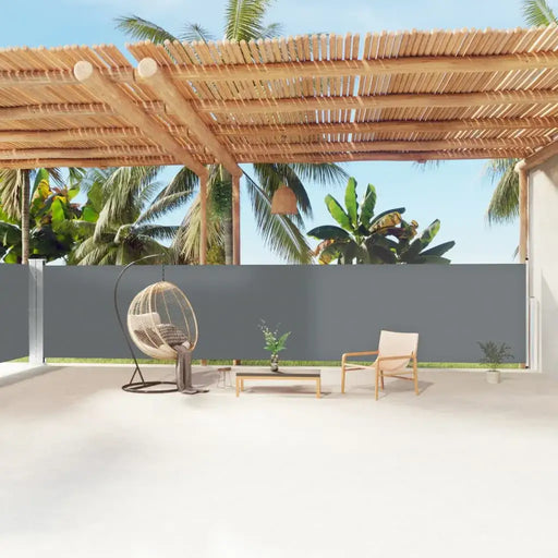 Garden patio with anthracite double-sided awning, rattan chair, and palm trees