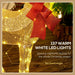Golden glittering reindeer decoration with 137 warm white LED lights and red mesh bow on wooden floor