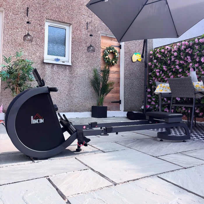 Rowing machine on a patio with a house and garden in the background