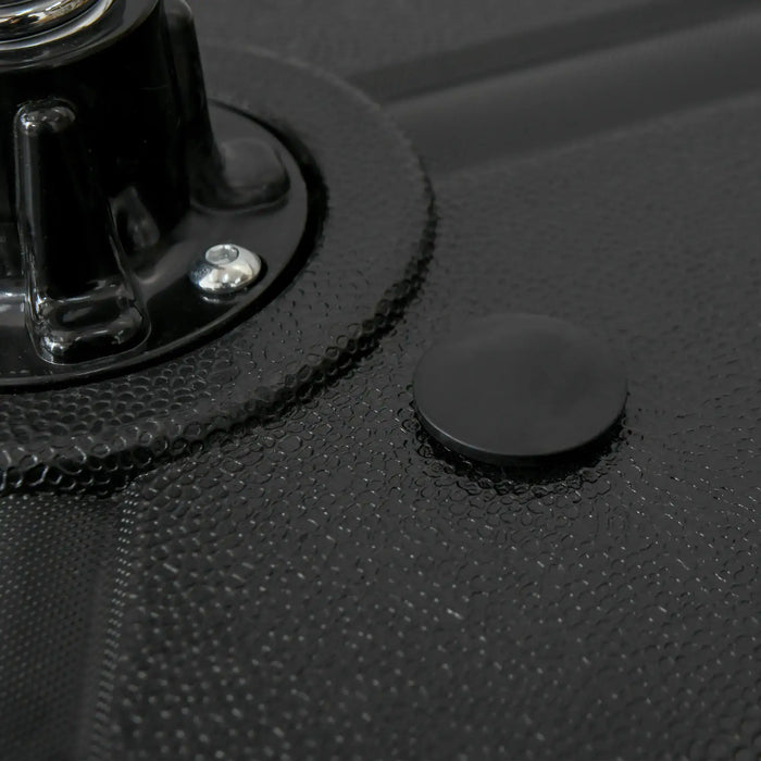 Close-up of black textured surface with circular knob and metal screw detail