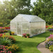 Walk-in aluminium frame greenhouse with double-walled polycarbonate panels in a flower garden