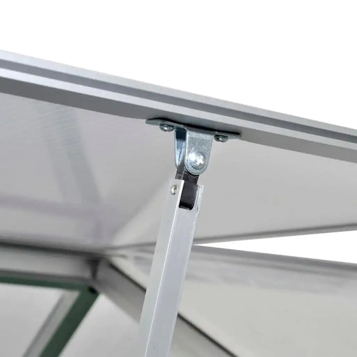 Close-up of polycarbonate greenhouse panel with aluminum frame and hinge support