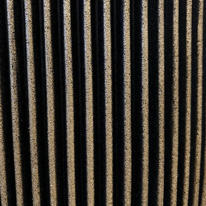 Close-up of black and gold grooved vase texture with vertical striped pattern