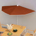 Half round terracotta garden parasol over wooden outdoor dining set on patio