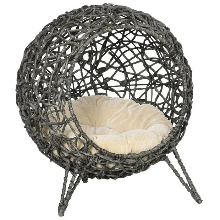Hand-woven rattan cat house with tripod legs and a beige cushion, elevated wicker basket