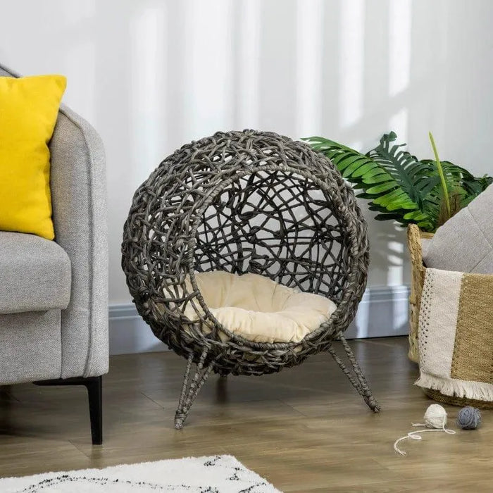 Hand-woven rattan cat house with tripod legs and cushion in modern living room