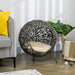Hand-woven rattan cat house with tripod legs and cushion in modern living room