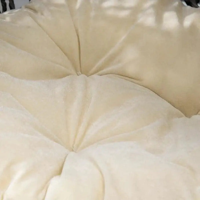 Close-up of soft beige cushion in a hand-woven rattan cat house basket