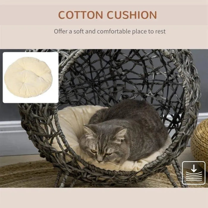 Grey cat on cotton cushion in hand-woven rattan cat house with tripod wicker legs
