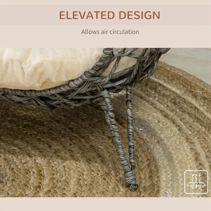 Hand-woven rattan cat basket with tripod legs and cushion on a braided rug