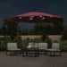 Bordeaux red hanging parasol with LED lights over patio furniture at night