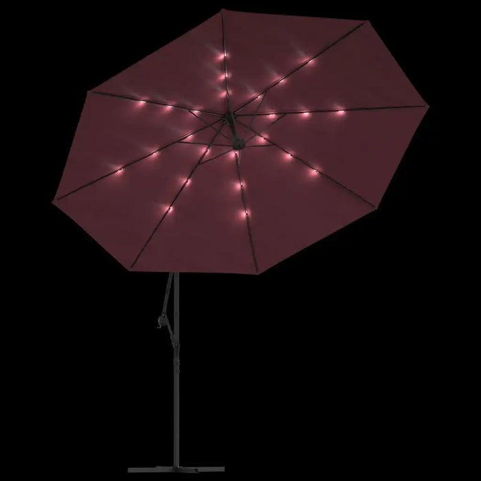 Bordeaux red hanging parasol with LED lights on black background