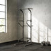 Gym power rack in a room with concrete walls and a window.