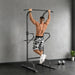 Man exercising on a pull-up bar in a home gym setting.