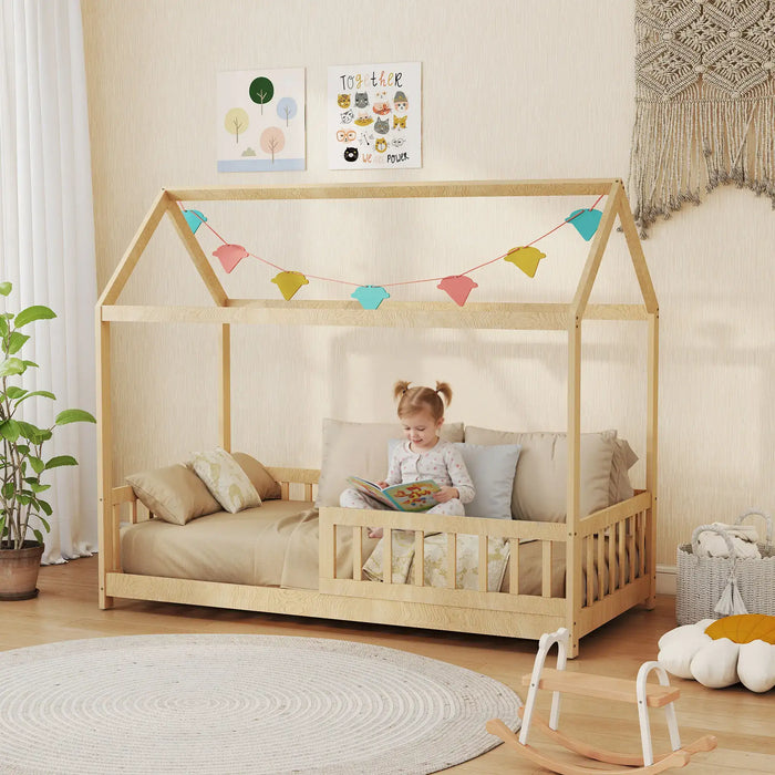 Child reading a book in a wooden house-shaped bed with colorful flags in a cozy room.