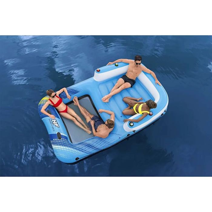 Four people relaxing on a Hydro Force inflatable floating lounger in blue water.