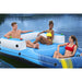 Three people relaxing on a blue and white floating lounger on a lake