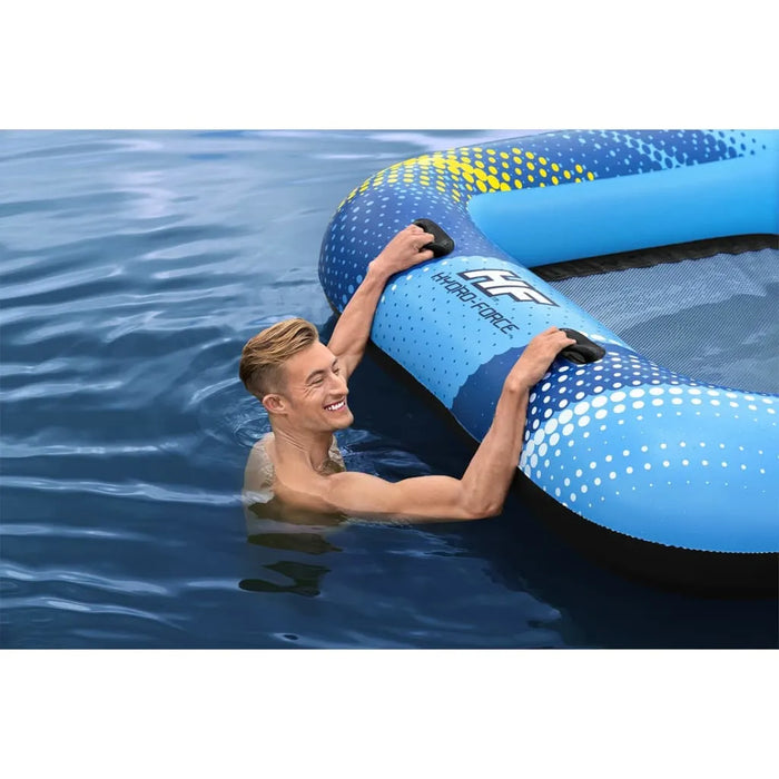Man in water holding blue Hydro-Force UV-protected floating lounger
