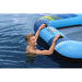 Man in water holding blue Hydro-Force UV-protected floating lounger