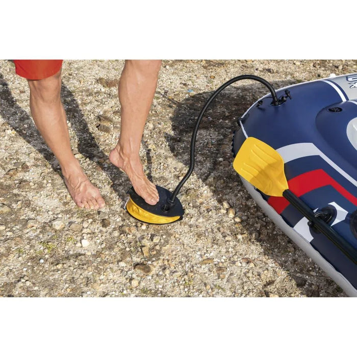 Person inflating Hydro Force Treck X2 inflatable boat with foot pump on rocky shore