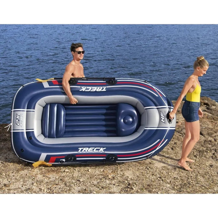 Two people carrying a Hydro-Force Treck X2 inflatable boat by a lake shore