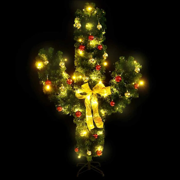 Cactus-shaped Christmas tree decorated with red and gold ornaments, yellow lights, and a yellow bow