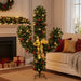 Christmas cactus-shaped wreath decorated with red and gold ornaments, yellow lights, and gold ribbon in cozy living room