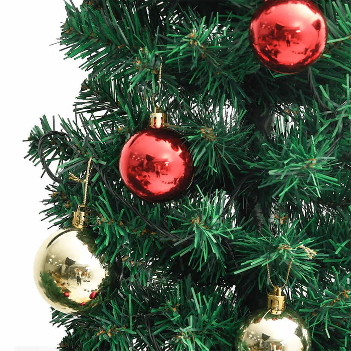 Green Christmas tree decorated with shiny red and gold baubles