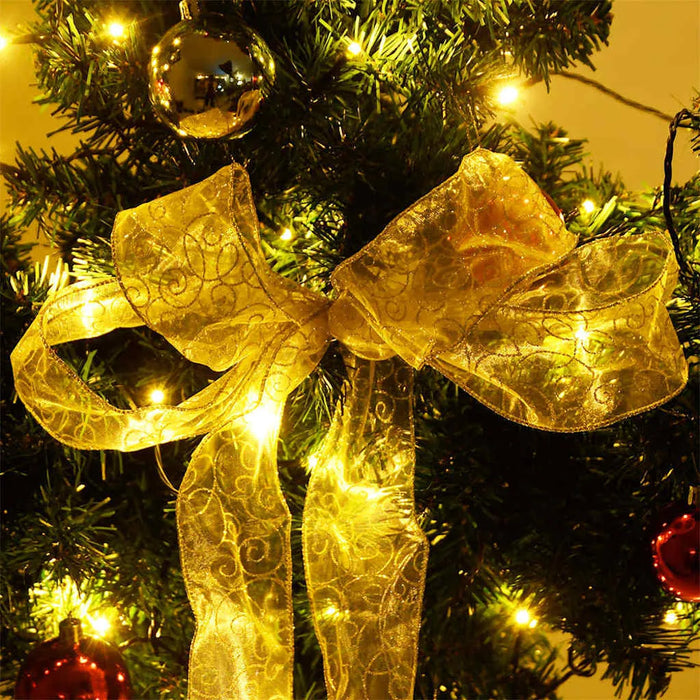 Christmas tree decorated with golden bow, red and silver baubles, and warm yellow fairy lights