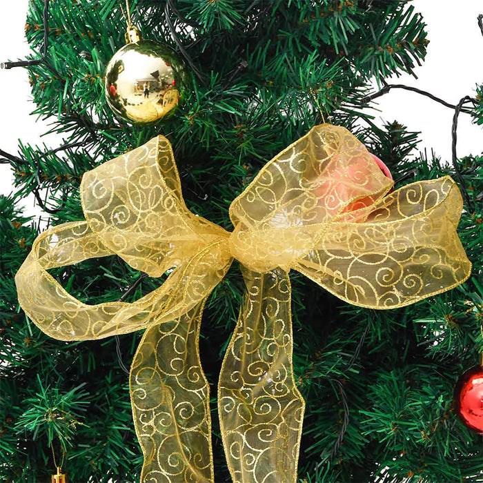Green Christmas tree decorated with gold ribbon bow and shiny gold and red baubles