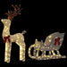 Lit Christmas decoration featuring a reindeer with antlers and a sleigh with red bows on black background