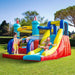 Kids playing on colorful inflatable castle with slide, pool, and climbing wall outdoors