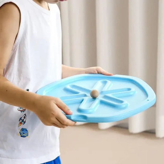 Child holding blue interactive kids balance board ball game indoors