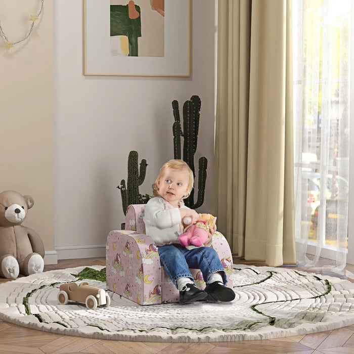 Toddler sitting on pink unicorn-themed chair in a bright nursery with cactus, toy car, and teddy bear