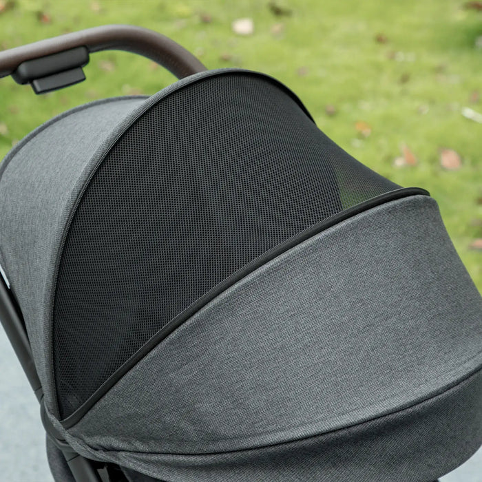 Gray stroller canopy with mesh window on a grassy background